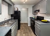 Thumbnail 1 of 14 - Kitchen with black appliances in Stockbridge GA apartment at Southwinds Point near Eagles Landing