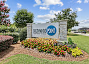 Thumbnail 18 of 18 - A sign for Southwinds Point Apartment Homes is surrounded by flowers and greenery.