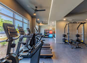 Thumbnail 2 of 23 - Spacious fitness center with cardio machines and floor-to-ceiling windows at Springview Apartments near South DeKalb.