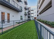 Thumbnail 25 of 28 - a grassy area on the balcony of an apartment building