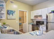 Thumbnail 1 of 19 - Duluth, GA Apartments – Grande Club – A kitchen with a refrigerator, sink, and cabinets.