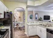 Thumbnail 5 of 19 - A kitchen with a black fridge and a white counter.