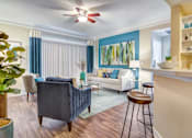 Thumbnail 7 of 19 - A living room with a blue chair and a white couch.