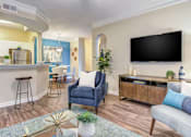 Thumbnail 8 of 19 - A living room with a blue chair and a black TV.