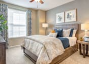 Thumbnail 12 of 19 - A bedroom with a large bed and a ceiling fan.