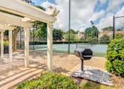 Thumbnail 14 of 19 - A tennis court is surrounded by a white pergola and a mailbox.