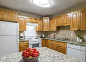 Thumbnail 10 of 29 - Kitchen at Stratford Ridge Apartments in Marietta, GA, showcasing warm wooden cabinets and clean white appliances, offering a bright and functional cooking space.
