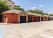 Thumbnail 16 of 20 - Sugar Mill Apartments in Addis, LA photo of a row of garages at the end of a parking lot