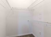 Thumbnail 8 of 20 - Sugar Mill Apartments in Addis, LA photo of a walk in closet with white walls and a shelf