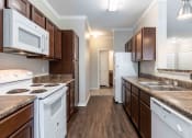 Thumbnail 5 of 20 - Sugar Mill Apartments in Addis, LA photo of a kitchen with white appliances and brown cabinets