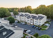 Thumbnail 19 of 21 - Sugar Creek Apartments Winston-Salem aerial photo showing apartment homes, parking, and wooded neighborhood setting