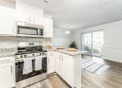 Thumbnail 7 of 21 - Winston Salem NC apartments for rent kitchen with granite counters stainless appliances and balcony at Sugar Creek Apartments