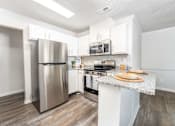 Thumbnail 6 of 21 - Spacious upgraded apartment kitchen with stainless appliances and granite countertops at Sugar Creek Apartments Winston Salem