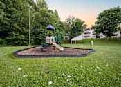 Thumbnail 17 of 21 - Outdoor playground and green space at Sugar Creek Apartments Winston Salem