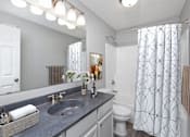 Thumbnail 8 of 14 - A bathroom with a white toilet, sink, and shower curtain.