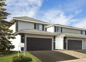Thumbnail 13 of 14 - Burnsville, MN Townhomes – Summit Townhomes - house with a garage door and a sign in front of it