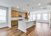 Thumbnail 2 of 25 - a kitchen and living room with hardwood floors and white walls