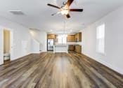 Thumbnail 4 of 25 - Park Circle Home Rentals - Sumner Village - Open-Floor Living Room With Vinyl Plank Flooring, Ceiling Fan, And Easy Access To A Toilet And Kitchen