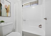 Thumbnail 9 of 21 - Bright bathroom with tub and white finishes at Sunnyside Senior Apartments