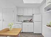 Thumbnail 11 of 21 - Kitchen with white cabinets and full appliances at Sunnyside Senior Apartments