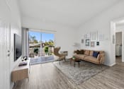 Thumbnail 5 of 21 - Bright living room with wood-style floors at Sunnyside Senior Apartments in San Dimas, CA