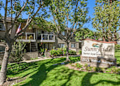 Thumbnail 20 of 21 - Community entrance monument sign surrounded by trees at Sunnyside Senior Apartments in San Dimas, CA.