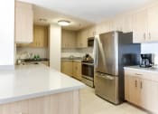 Thumbnail 16 of 29 - a kitchen with white countertops and wooden cabinets