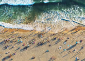 Thumbnail 26 of 29 - a beach with people and surfboards on the sand
