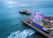 Thumbnail 25 of 29 - a ferris wheel on a pier with the ocean in the background
