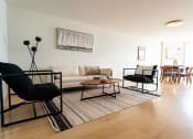 Thumbnail 1 of 29 - Apartments in Santa Monica for Rent - San Vicente Tower - Open Living Room with Hardwood Flooring, Stylish Decor, Dining Area, and Large Window