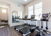 Thumbnail 27 of 55 - A gym with treadmills and elliptical machines.
