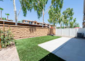 Thumbnail 25 of 55 - A backyard with a green lawn and a white fence.