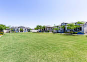 Thumbnail 48 of 55 - A row of houses with a green lawn in front.