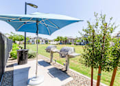 Thumbnail 45 of 55 - A blue umbrella is open over a picnic table.