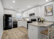 Thumbnail 1 of 19 - Jacksonville, FL Apartments – The Marley at Trout River - 
 kitchen with white cabinets and a black refrigerator