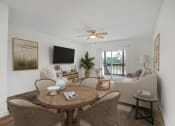 Thumbnail 5 of 19 - Pet Friendly Apartments in Jacksonville, FL – The Marley at Trout River – living room with a table and chairs and a ceiling fan