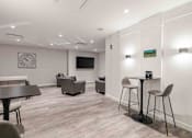 Thumbnail 8 of 27 - a living room with a table and chairs and a tv