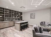 Thumbnail 9 of 27 - a living room with a kitchen and a couch