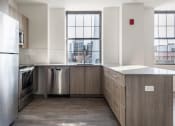 Thumbnail 12 of 27 - an empty kitchen with stainless steel appliances and a window