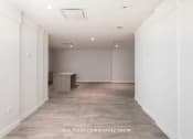 Thumbnail 11 of 27 - a large empty room with white walls and a wooden floor