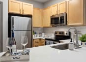 Thumbnail 1 of 29 - Sage at 1240 apartments in Mount Pleasant South Carolina photo of kitchen with stainless steel appliances and quartz countertops.