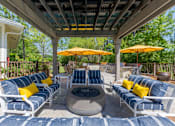 Thumbnail 14 of 32 - Outdoor seating area with a fireplace at The Sanctuary at 331 apartment complex in Santa Rosa Beach, Florida, featuring comfortable chairs arranged around the fire.