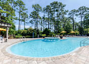 Thumbnail 11 of 32 - Outdoor swimming pool surrounded by lush landscaping and comfortable seating at The Sanctuary at 331 in Santa Rosa Beach, FL