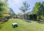Thumbnail 16 of 32 - A backyard with a lawn, a picnic table, and a house in the background.