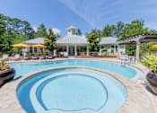 Thumbnail 10 of 32 - Resort-style swimming pool with lounge chairs and landscaped greenery at The Sanctuary at 331 in Santa Rosa Beach, FL