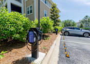 Thumbnail 21 of 32 - A parking lot with a car and a charging station.