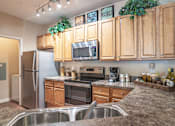 Thumbnail 5 of 24 - a kitchen with wooden cabinets and stainless steel appliances