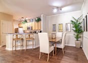 Thumbnail 6 of 24 - Apartments in Opelika for Rent – The Crossings of Opelika - a dining area with a table and chairs and a kitchen in the background