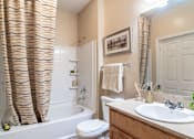 Thumbnail 10 of 24 - Opelika, AL Apartments – The Crossings of Opelika - a bathroom with a white toilet next to a white bathtub
