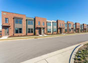 Thumbnail 16 of 16 - Apartments for Rent in Gallatin, TN - The Gardens at Preston Park - Street View of Brick Property Exterior, with Large Windows and Plant Beds.